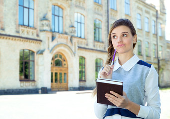 Beautiful young woman holding notebooks. Woman student.