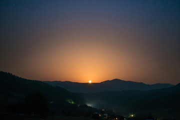 Moon rising on night sky
