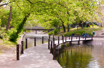 Fototapeta na wymiar Wood path over river in city park