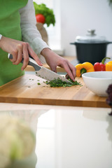 Closeup of human hands cooking vegetables salad in kitchen on the glass  table with reflection