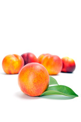 fresh peach fruits with green leaves isolated on white background