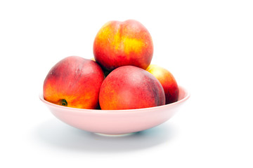 Ripe peaches in bowl isolated on white