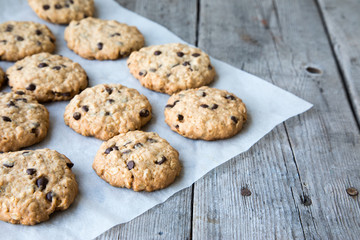 oatmeal cookies with chocolate on an old wooden background