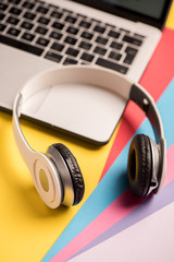 Plakat headphones and laptop computer closeup. online music concept.