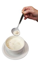 Cream soup in white cup with scoop isolated white background