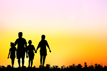 Fototapeta na wymiar silhouette family walking on blurry colorful sky at sunset time 