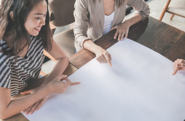 businesswoman pointing at their plan on paper during meeting