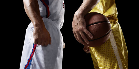 Two basketball players stands face-to-face before the game. Isolated basketball players on a black...
