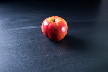 Fototapeta na wymiar one single red apple on dark background
