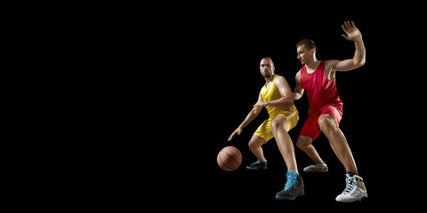 Two basketball players fight for the basketball ball. Isolated basketball players on a black...