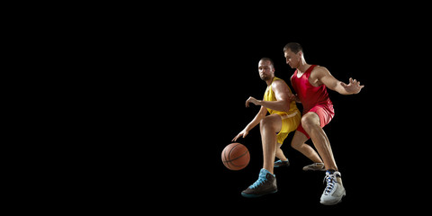 Two basketball players fight for the basketball ball. Isolated basketball players on a black...