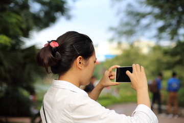 スマートフォンで写真を撮る女性