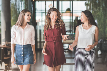 group of three best friend having conversation while walking tog