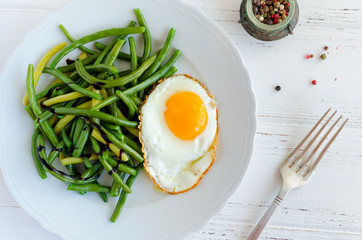 Cooked green beans with fried egg