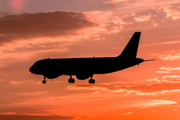 Airplane landing at sunset