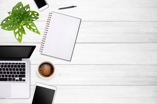 Modern workspace with laptop tablet, smartphone and coffee cup copy space on white wood table background. Top view. Flat lay style.