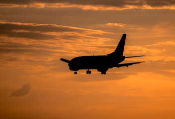 Airplane landing at sunset