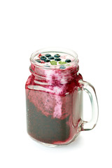 Jar of  blueberry smoothie on white