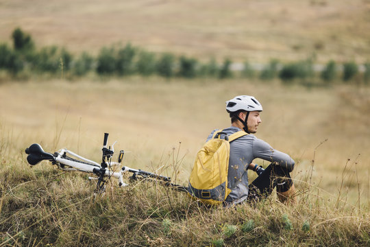 Man With a Bicycle Sitting in Nature