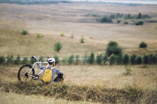 Man With a Bicycle Sitting in Nature