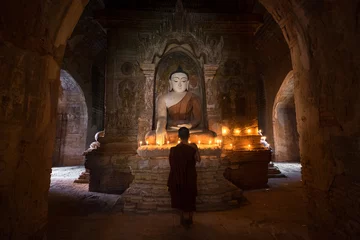Poster Boeddha Jonge beginnende monnik bidden met kaarsen voor Boeddhabeeld in oude pagode, Bagan Myanmar