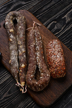 Three types of dried spicy sausage/Several kinds of dried Spanish sausage on a wooden cutting board.Top view
