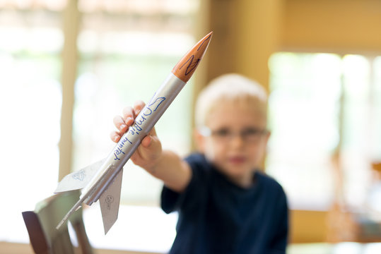 Creative Little Boy Rocket Scientist Showing Off Home Made Model Rocket Ready For Flight