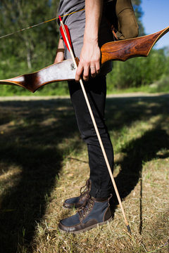 Woman standing with bow and arrow in hand