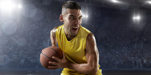 Basketball player hold a basketball ball on big professional arena. Player is preparing to throw...