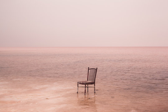 Broken chair in pink lake