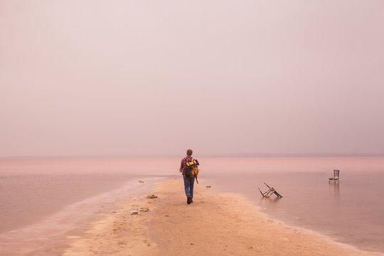 Tourist walking near pink lake