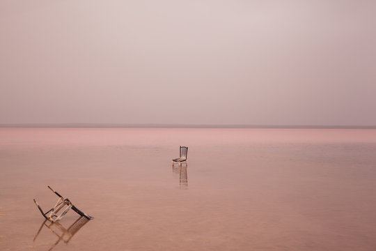 Broken chair in pink lake