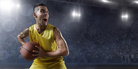 Basketball player hold a basketball ball on big professional arena. Player is preparing to throw...