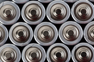 Obraz premium Close up top view on blurred rows of AA batteries energy abstract background of batteries. Shallow depth of field.