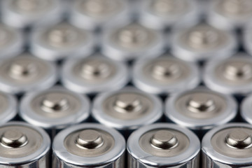 Close up top view on blurred rows of AA batteries energy abstract background of batteries. Shallow depth of field.