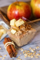 Healthy snack of oatmeal porridge with apples and cinnamon on marbel surface