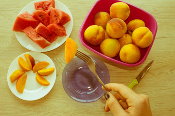 Slices tasty watermelon and peaches on a white plate. Triangle s