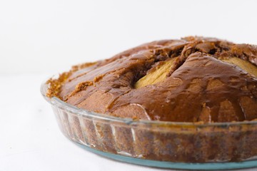 Freshly baked homemade pear pie in glass tray isolated on white
