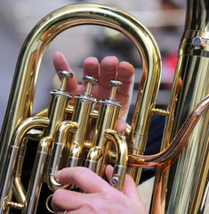 hand of boy plays the trombone in the brass band