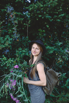 Portrait of a young woman with flowers and plants collected in the woods