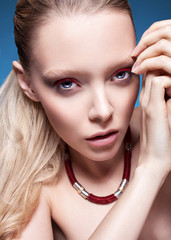 Fototapeta premium Luxury blond girl with red eyeshadow and blue eyes. Perfect skin. Stylish make-up.