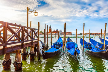 Fototapeta na wymiar Gondolas near dock in Venice Italy with view to San Giorgio