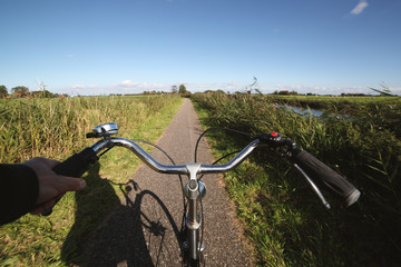 Man cycling between river and meadows