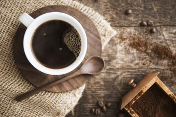 Coffee in a cup with ground coffee and beans
