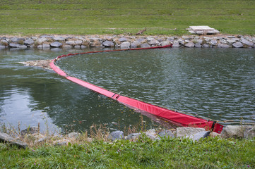 Plastic boom in the river. Barrier and obstacle contain and prevent spreading of pollution,...