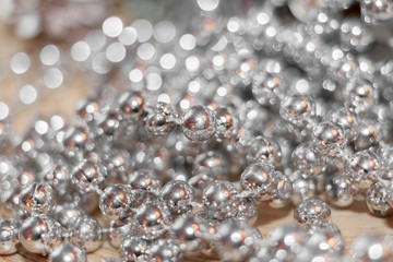 Abstract christmas backgrounds. Thread with beads is lying randomly on wooden table and beautiful bokeh.