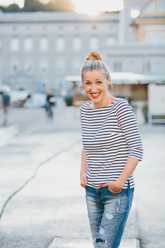 Woman with Hands in Pockets in City Square