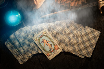 Tarot card / View of tarot card on the table under candlelight. The World. Dark tone. - obrazy, fototapety, plakaty