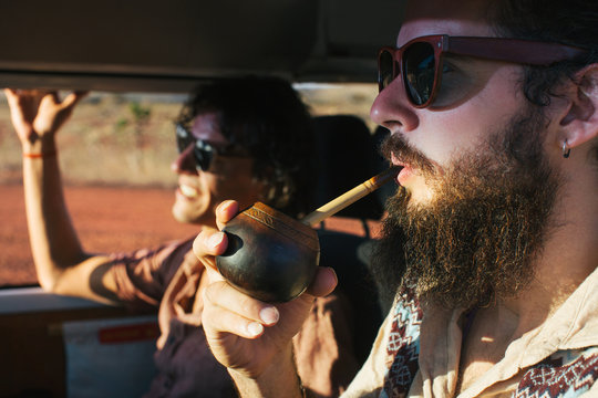 Hippie Road Tripping - Profile of Bearded Male Hippie Drinking Mate While Driving Camper Van
