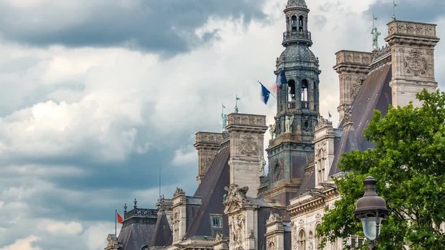 Architecture of The Hotel de Ville City Hall with french flag on tower timelapse, the building housing the local administration of the city of Paris